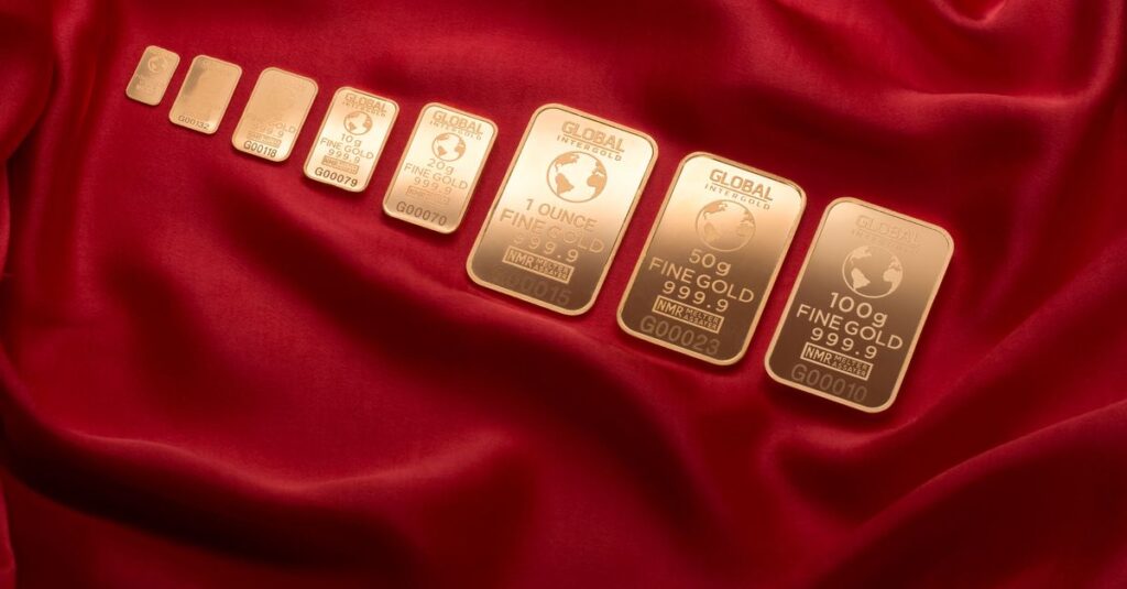 股票變黃金!股票出借全圖解:3步驟開啟被動收入,睡覺也在賺錢! Array of fine gold bars displayed on rich red fabric, symbolizing wealth and luxury.